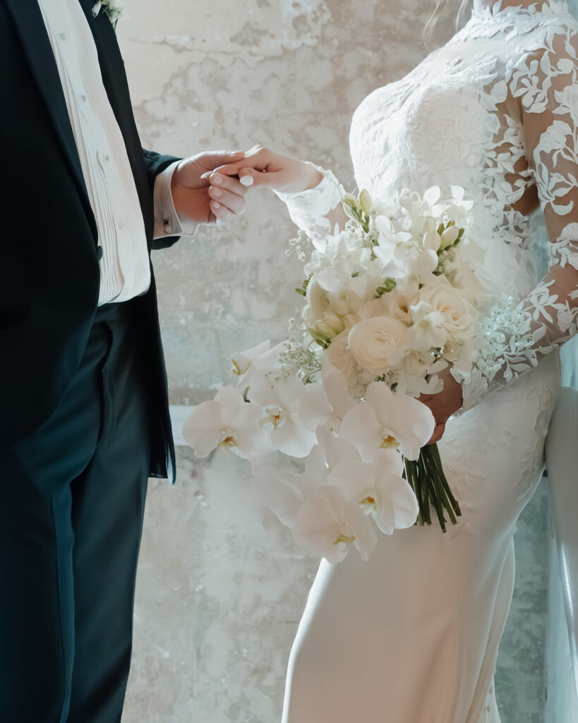 groom holds his bride's hand