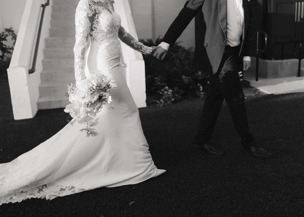 bride and groom hold hands