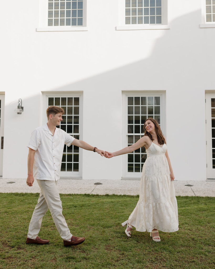 man and woman walk alongside the rosemary beach town hall
