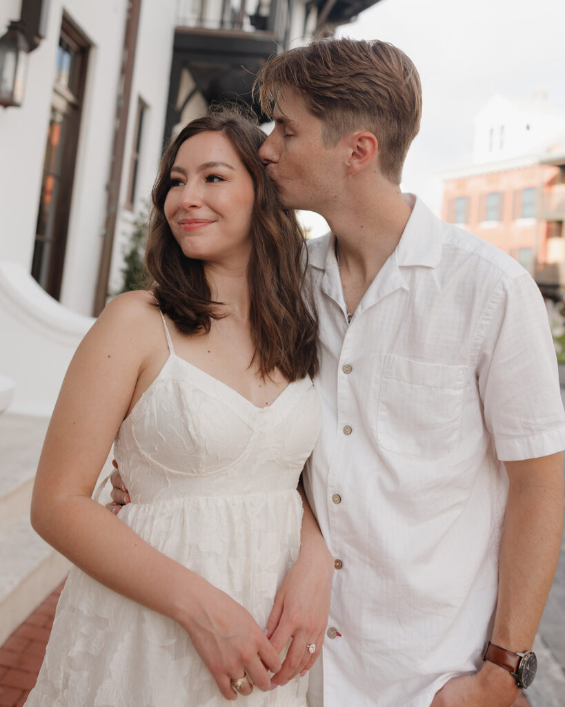 man kisses woman's head