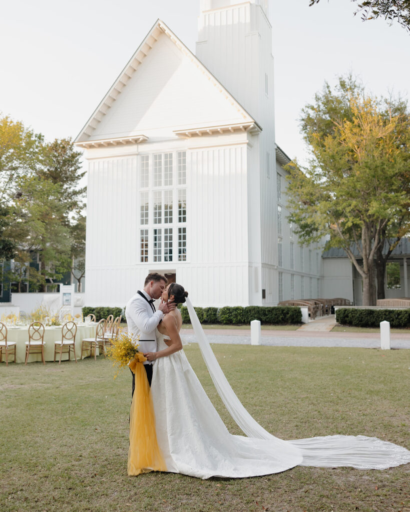 bride and groom kiss on the lawn in Seaside