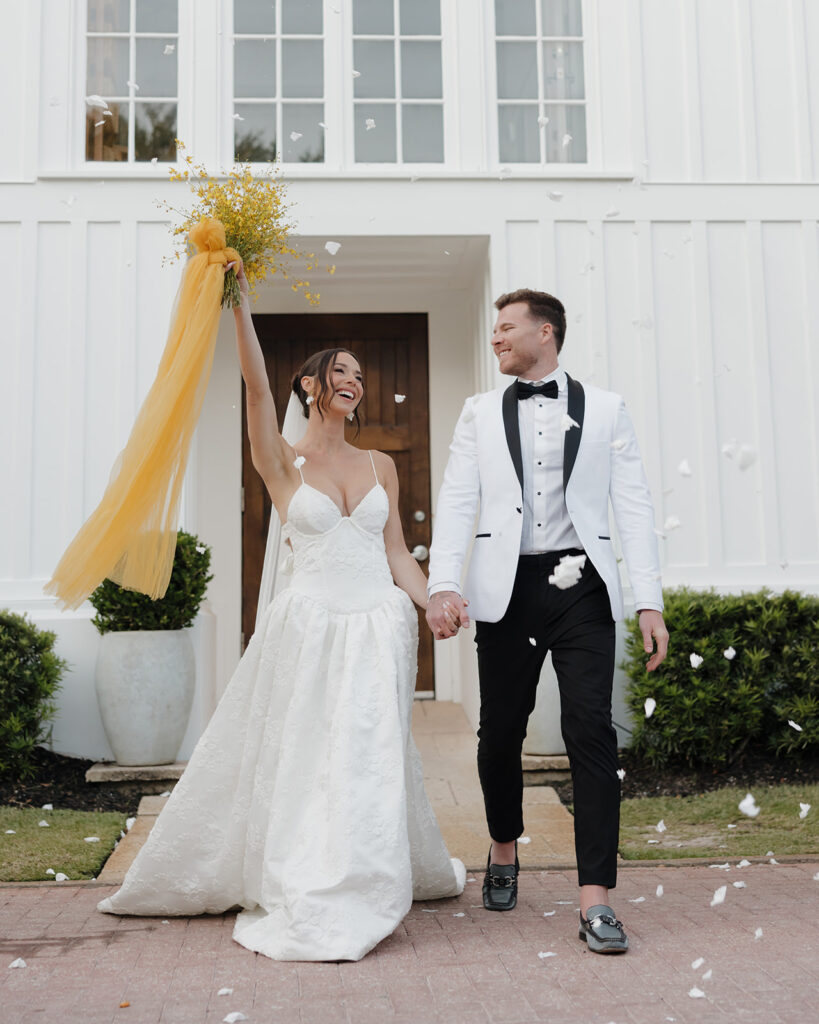 bride and groom cheer as petals are tossed