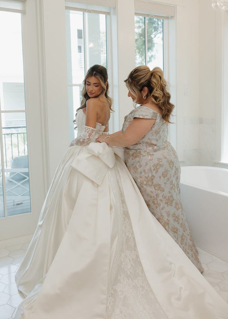 bride's mother ties her corset dress