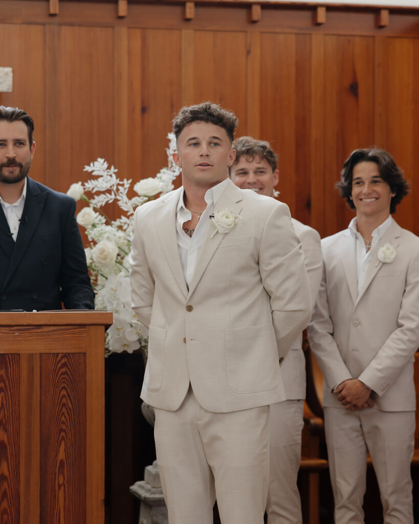 groom watches his bride walk down the aisle