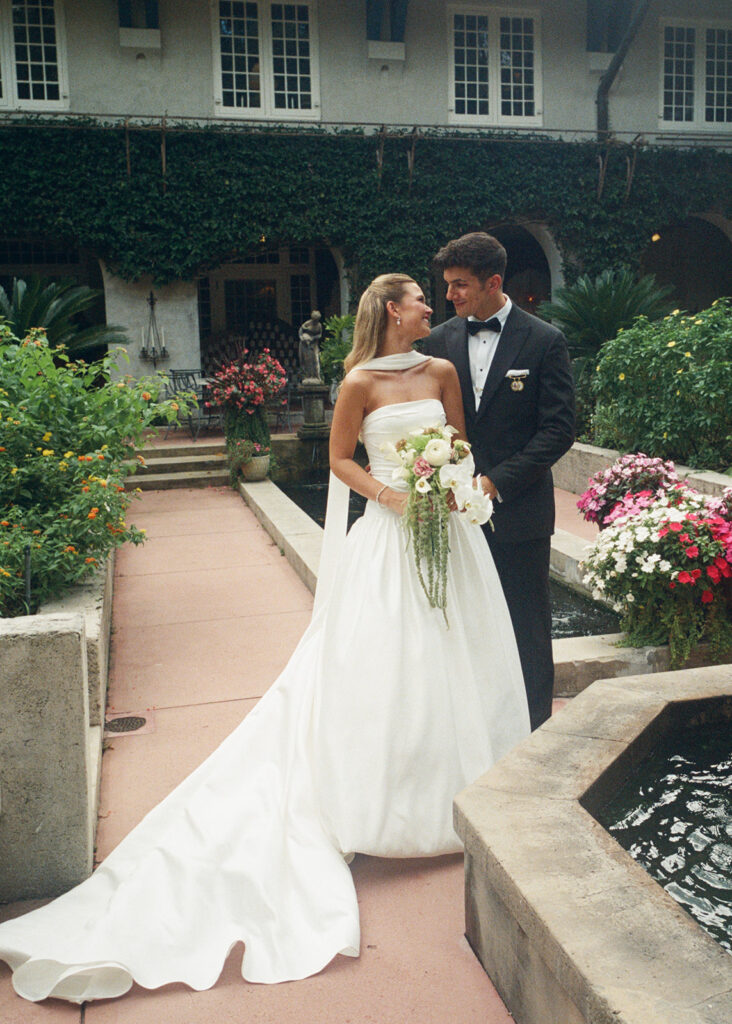 bride and groom exchange smiles in the garden of Sydonie Mansion