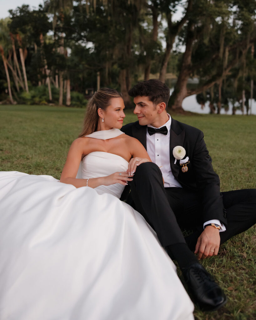 bride and groom sit in the field