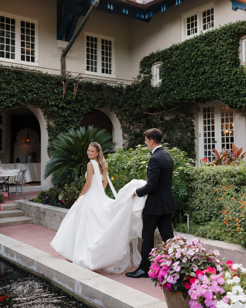 bride and groom walk through the garden of Sydonie Mansion in Mount Dora, FL